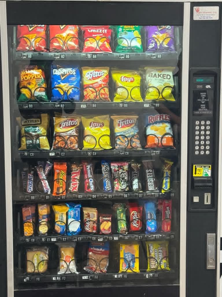 Vending machine fully stocked with chips, candy, and snacks